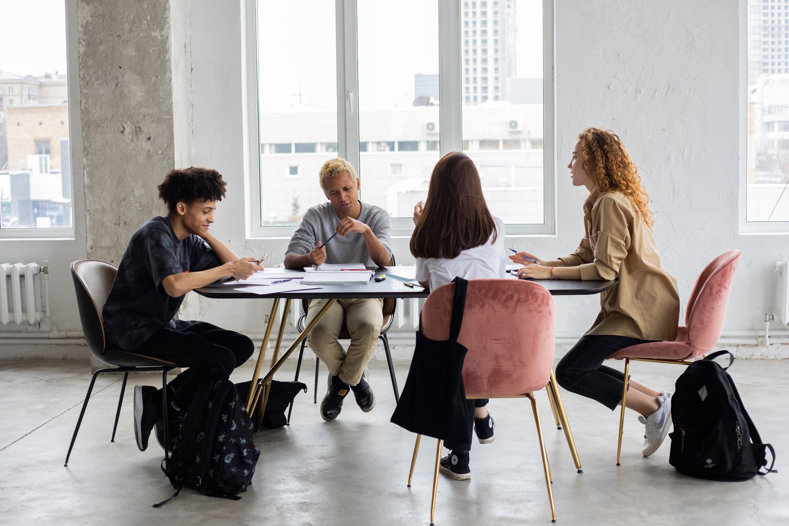 Estudiantes intercambiando ideas alrededor de una mesa