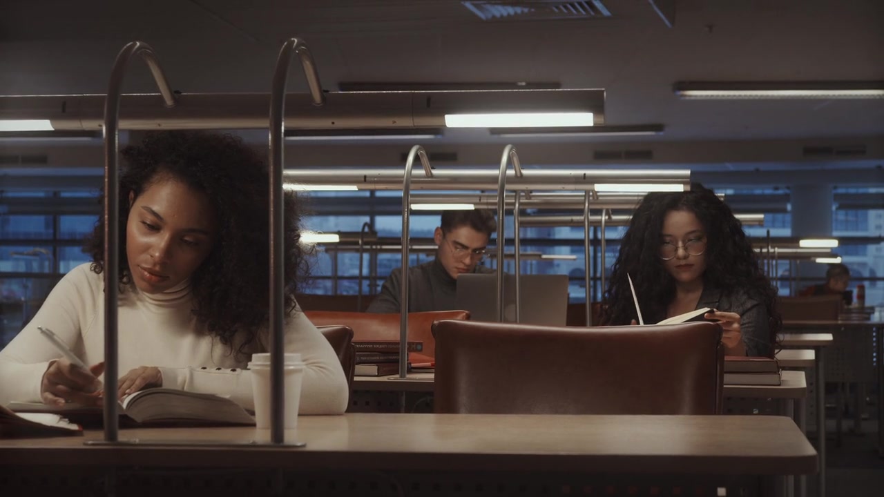 Personas leyendo y escribiendo en una biblioteca